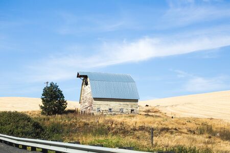 Vintage farm building under blue sky in the Palouse area of Washington state, USA.