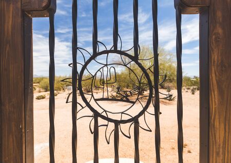 Metal cactus and sun shapes in an outdoor gate in a desert area.の写真素材