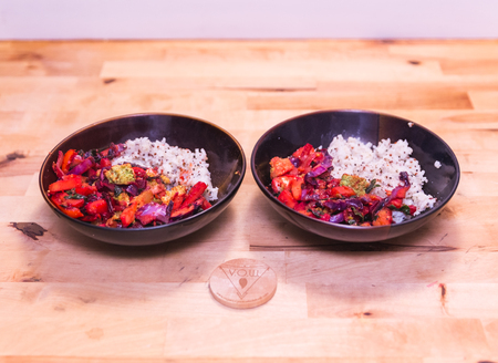 Two bowls filled with veggies, rice, and spices for a healthy vegan meal.の写真素材