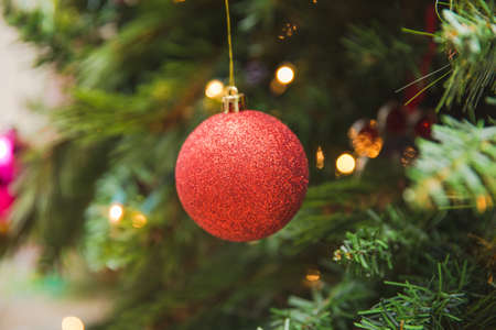 Shimmering and sparkling glass ornaments hang in a green Christmas tree. Traditional Christmas ornaments in tree.の写真素材