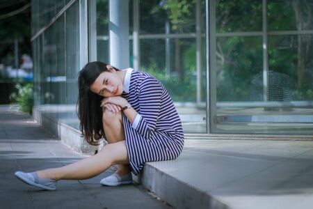 casual beautiful woman in front of office glass wallの写真素材