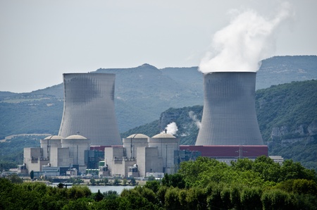 Nuclear plant generating electricity. Two towers among hills