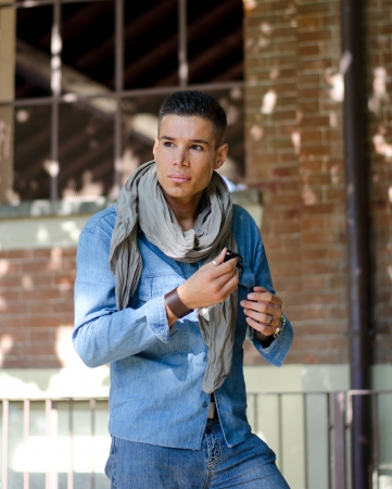 Handsome male model in blue jeans clothes and scarf, outdoorsの写真素材