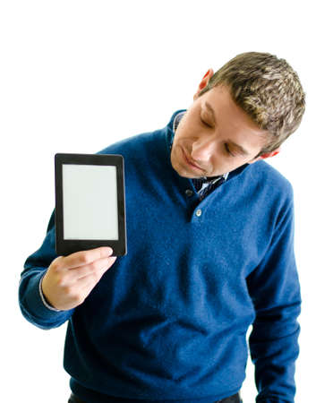 Handsome young man holding ebook reader and looking at it, isolated on whiteの写真素材