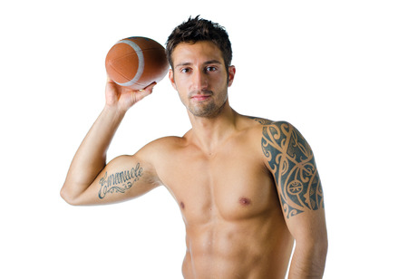 Attractive, fit, shirtless young man holding american football ball, isolated on whiteの写真素材