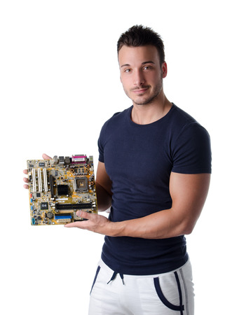 Smiling young man holding and showing computer motherboard and looking in cameraの写真素材