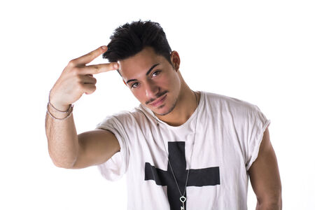 Hip, trendy young man with white t- shirt and necklace, isolated on white, doing peace sign with fingersの写真素材