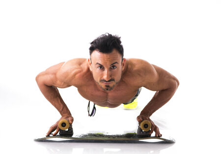 Shirtless muscular man on the floor with skateboard, isolated on white, looking at camera