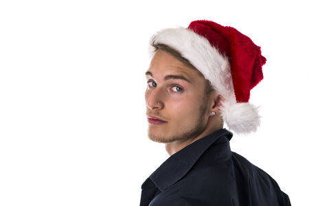 Handsome young man in Santa Claus red hat for Christmas, turning around and looking at camera, isolatedの写真素材