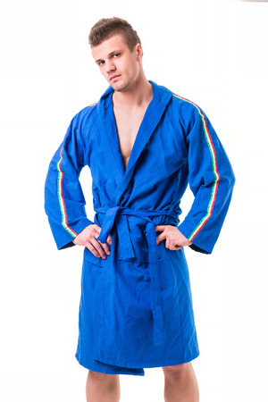 Handsome young man wearing blue bathrobe, isolated on white backgroundの写真素材