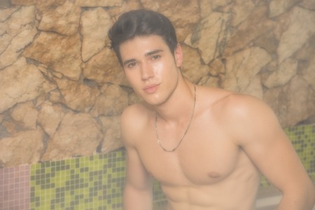 Young Shirtless Man Gazing Seductively at Camera and Relaxing in Steam Sauna - Turkish Bath -...