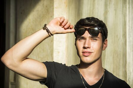 Head and shoulder shot of handsome attractive young man looking up, indoor, lit by sunlight