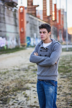 Attractive young man in urban environment standing with arms crossed on chestの写真素材