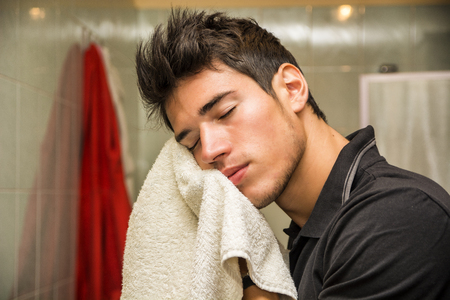 Young Man Drying Face with Towel as Part of Daily Hygiene Routineの写真素材