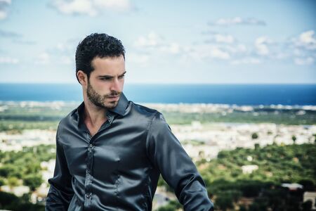 Portrait of elegant attractive young man with curly hairの写真素材