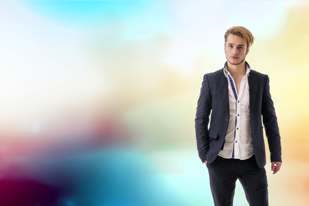 Portrait of handsome blond young man, blue eyes, on colorful abstract backgroundの写真素材