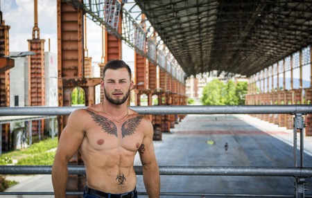 Handsome Muscular Shirtless Hunk Man Outdoor in City Setting. Showing Healthy Body While Looking awayの写真素材