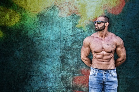 Handsome Muscular Shirtless Hunk Man Outdoor Against Colorful Self-Made Background. Showing Healthy Body While Looking awayの写真素材