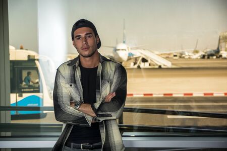 Portrait of a man in checkered shirt posing for camera at an airportの写真素材