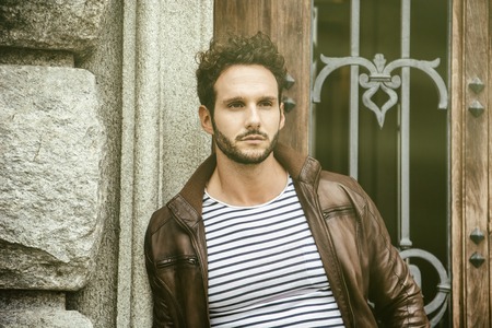 Attractive young man outdoor wearing leather jacket, in European city, Turin in Italyの写真素材