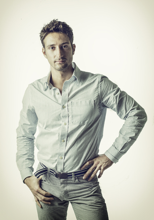 A different kind of young business man wearing shirt and ripped jeans, on light backgroundの写真素材