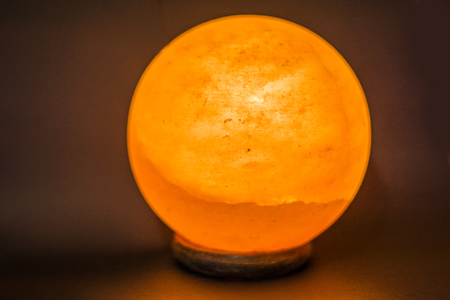 The lamp placed inside of the salt stone. Horizontal indoors shot of Himalayan salt round or spheric lampの写真素材