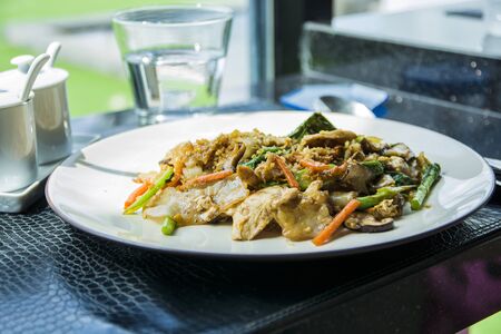 Close up shot of freshly made Thai dish with chicken served on white plate.の写真素材