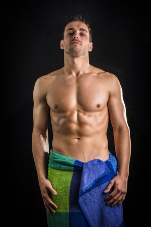 Portrait of naked handsome young man with languishing look with a towel around his waistの写真素材