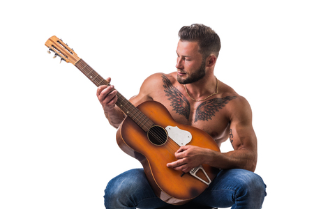 Portrait of muscular man with tattoo playing guitar. Isolated on white background. Full length shotの写真素材
