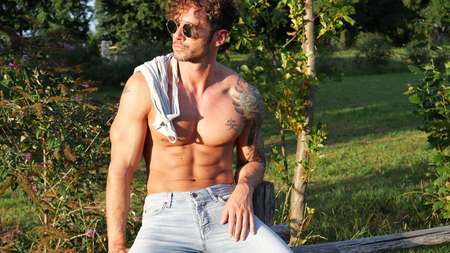 Handsome Muscular Shirtless Hunk Man Outdoor in Country Standing on Grass. Showing Healthy Muscle Body While Looking awayの写真素材