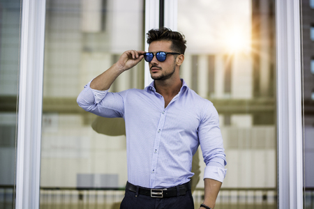 One handsome elegant young man in urban setting in European city, standingの写真素材