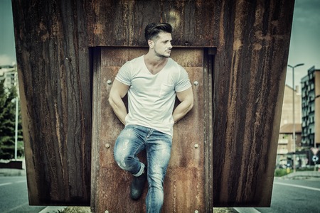 Attractive man in urban setting in front of big metal structureの写真素材
