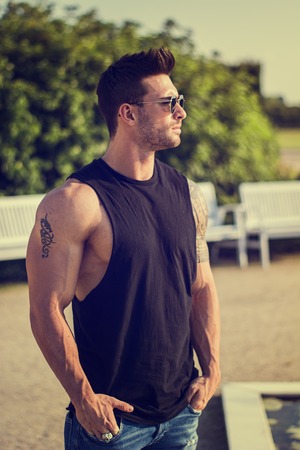 Handsome muscular man with tattoo posing in European luxury garden in Turin, Italyの写真素材