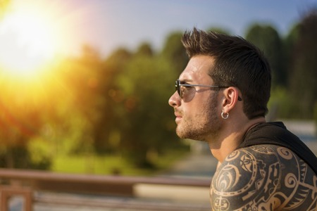 Handsome muscular man with tattoo posing in European luxury garden in Turin, Italyの写真素材