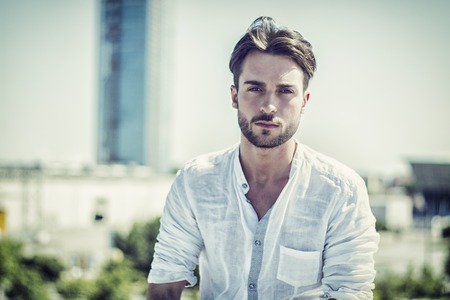 One handsome young man in urban setting in European city, standingの写真素材