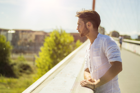 One attractive young man in urban setting in modern city, leaning against balustersの写真素材