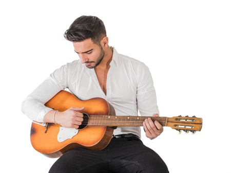 Handsome young man in bow-tie with guitar looking at camera. Studio shot isolated on white backgroundの写真素材