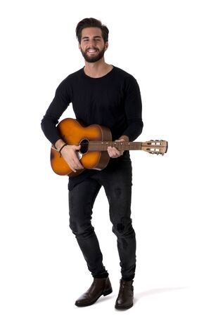 Full Length Portrait of Young Man Wearing Black Outfit Playing Classic Guitar in Studio with White Backgroundの写真素材