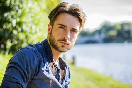 One handsome young man in urban setting in European city, Turin in Italy by the river Po