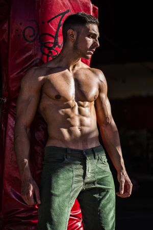 Handsome Muscular Shirtless Hunk Man Outdoor in City Setting. Showing Healthy Body While Looking...