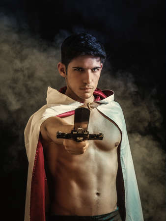 Handsome man in old fashioned cloak with swordの写真素材