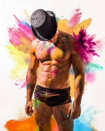 Muscular man shirtless with skin painted with Holi colorsの写真素材