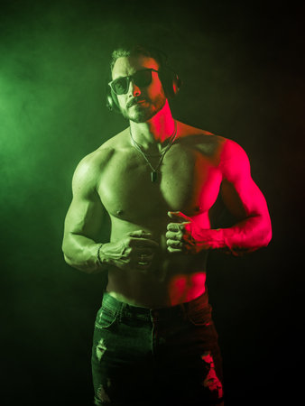 Shirtless muscular male bodybuilder in studio shot on black