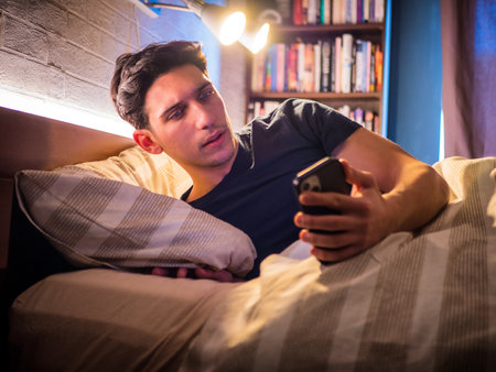 Man checking notification on smartphone at nightの写真素材