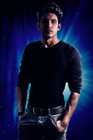 Handsome and fit young man standing on dark backroundの写真素材