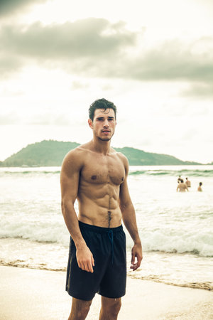 Handsome young man standing on a beach in Phuket Island, Thailandの写真素材