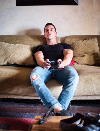 Attractive guy playing videogames with joystick in handの写真素材