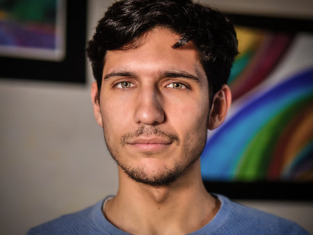 Handsome young man with serious expression at home