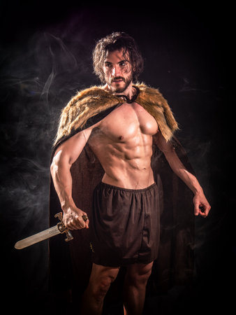 Brutal viking man in fur cloak with swordの写真素材
