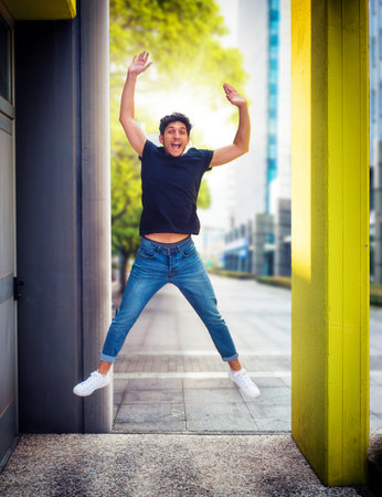 One handsome young man jumping for joy and laughing